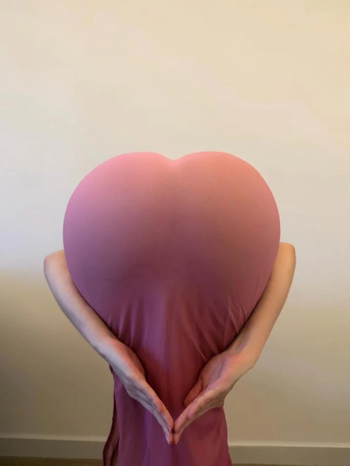 Heart Butt Challenge — Close-up of person in gray leggings forming a heart shape with bent-over pose